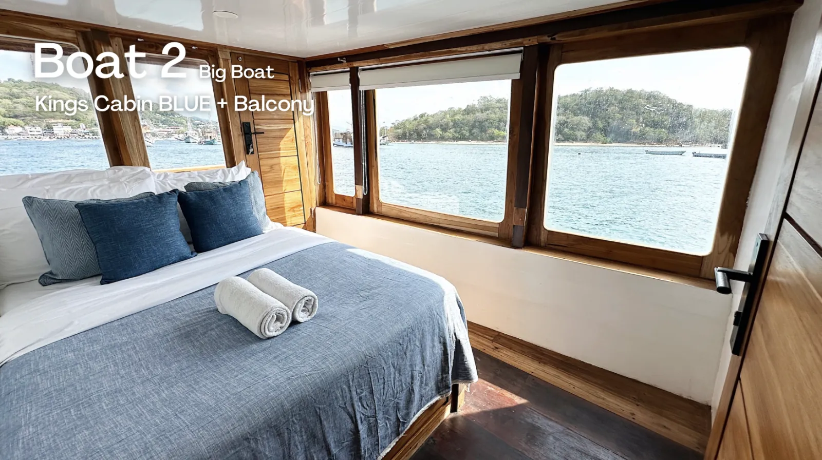 Kings cabin with queen bed and sea-view windows aboard the Komodo Phinisi