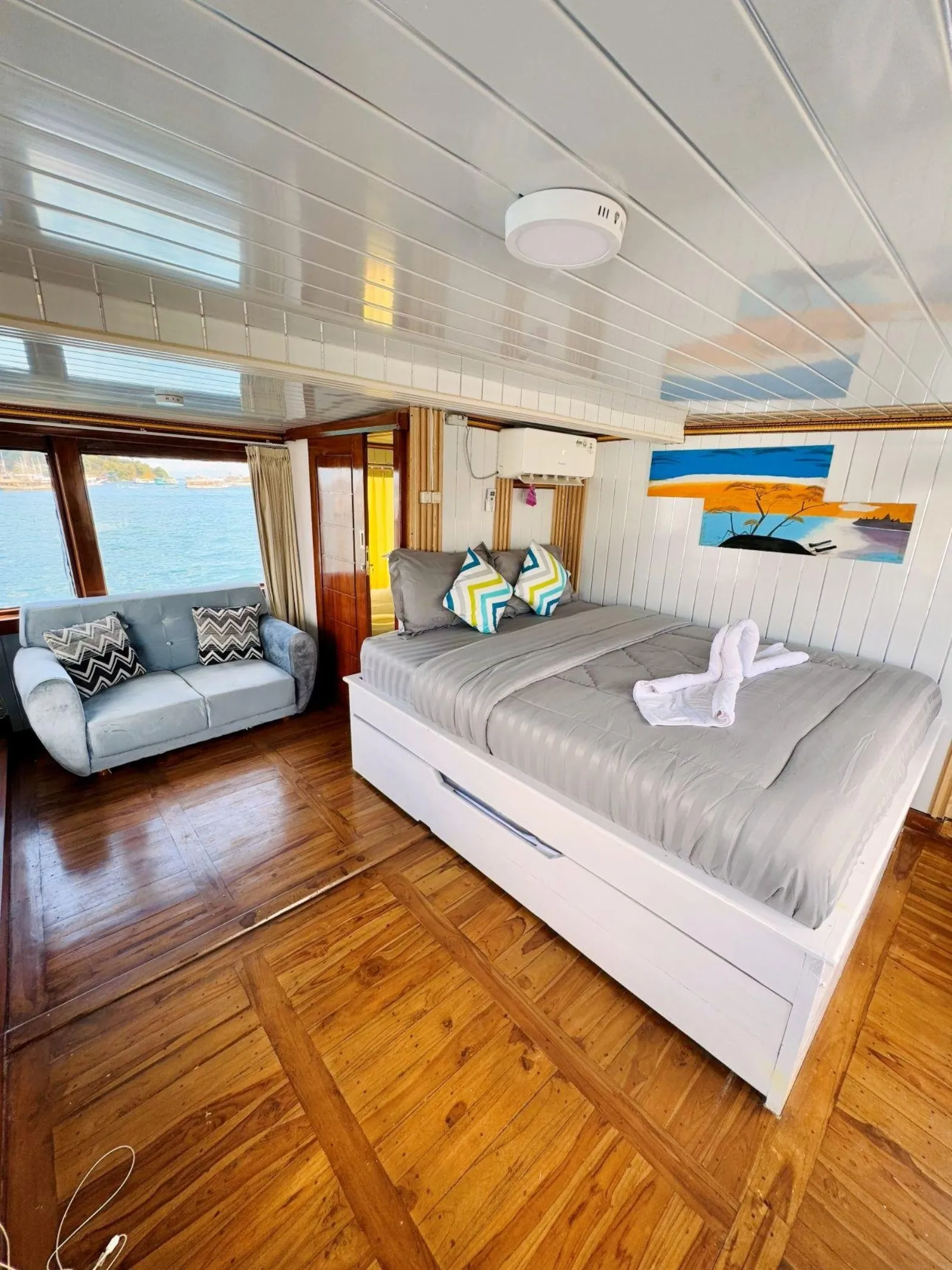 Air-conditioned VIP cabin with double bed and timber floor on the Komodo boat