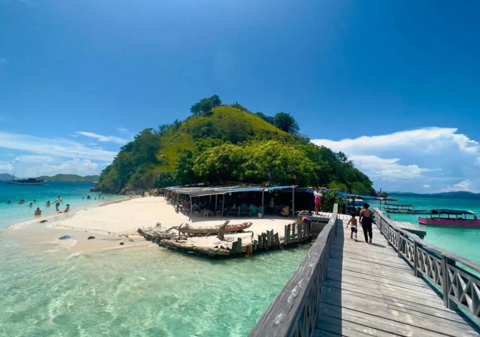 Timber jetty leading to a small green island in Komodo National Park