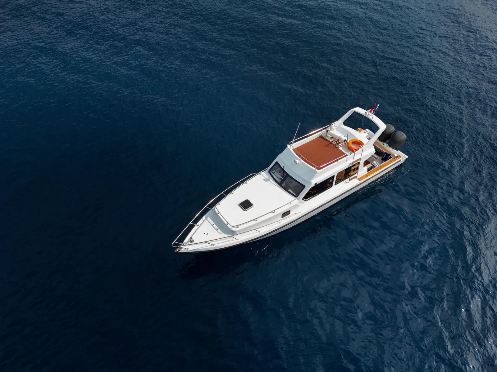 Aerial view of a white speedboat crossing deep blue water near Komodo