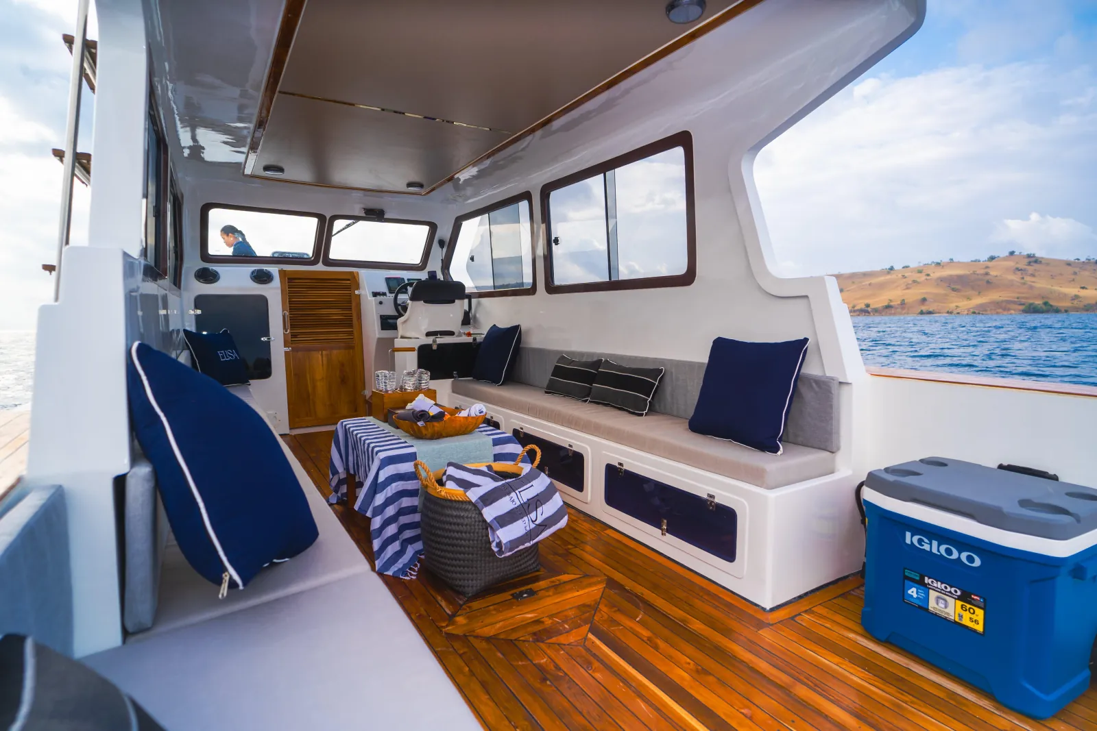 Timber deck lounge and cool box aboard a Komodo National Park day boat