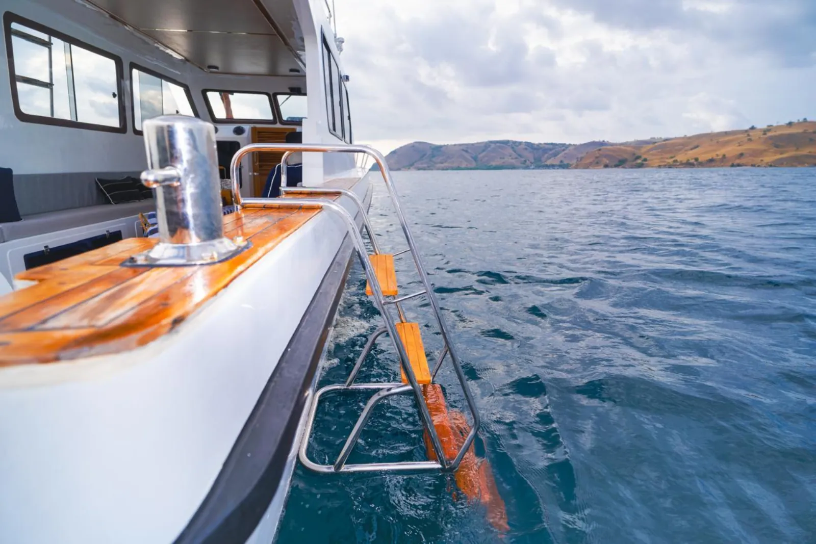 Boat rail and timber deck with Komodo National Park islands beyond