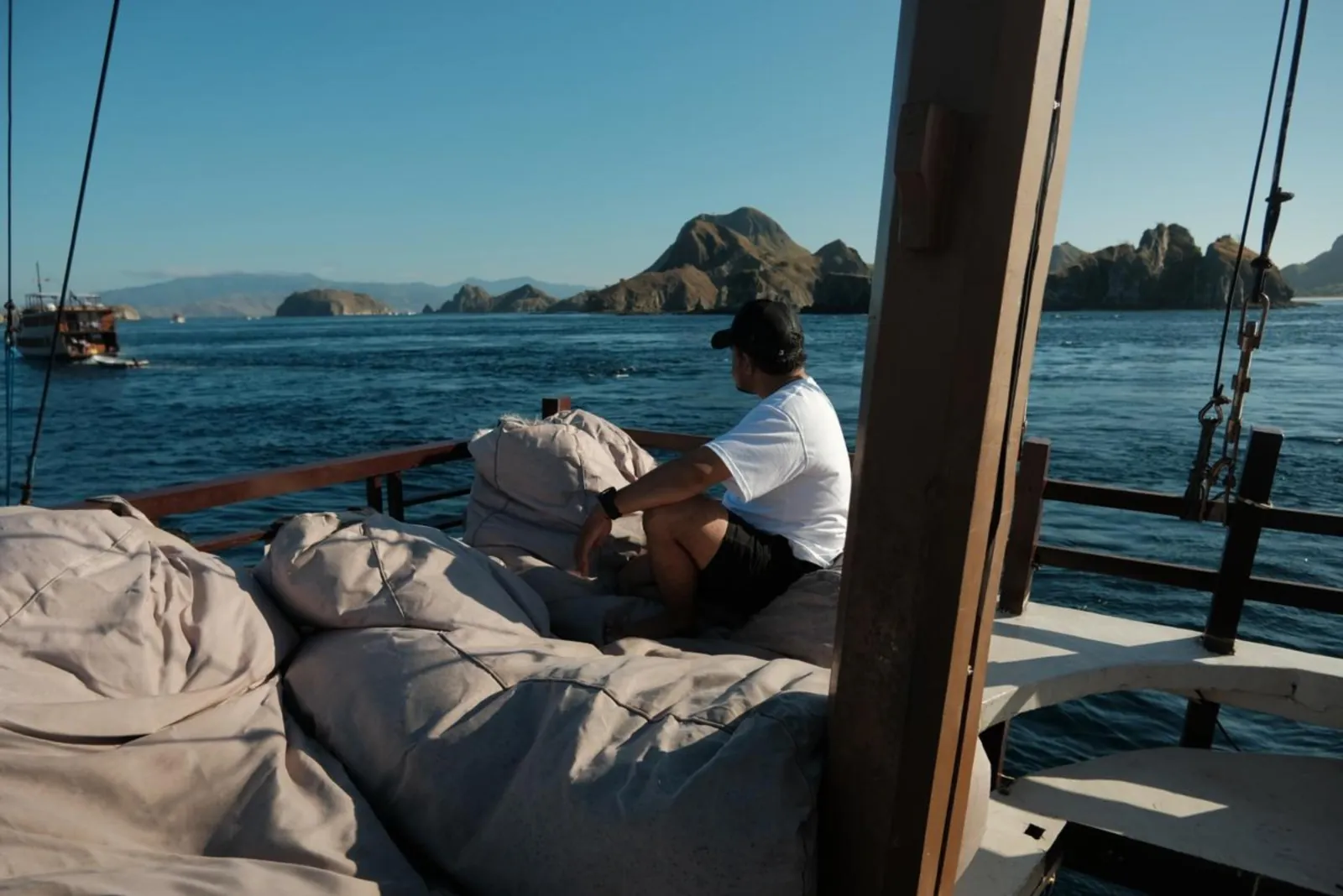 Guest resting on a bean bag on the open deck of a Komodo liveaboard