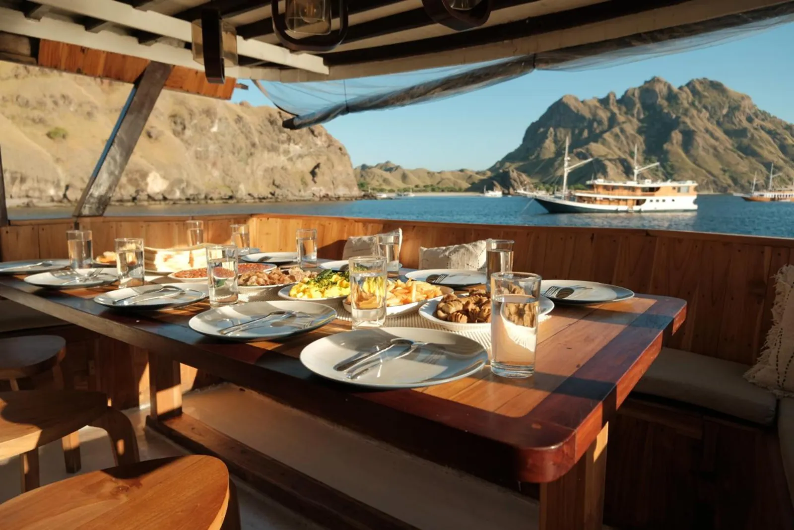 Dinner laid out on the timber table of a Komodo liveaboard at anchor
