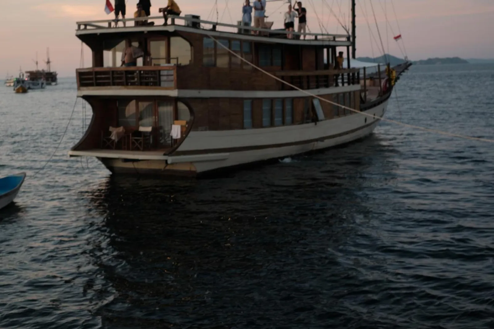 Two-deck wooden liveaboard boat under way in Komodo National Park