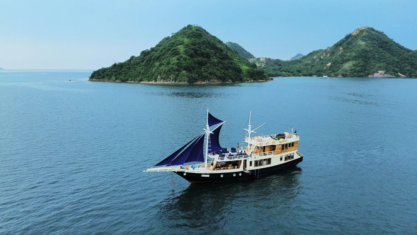 Traditional Phinisi liveaboard sailing between islands in Komodo National Park