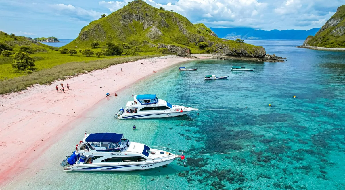 Speedboats moored off the pink sand and turquoise shallows of Pink Beach