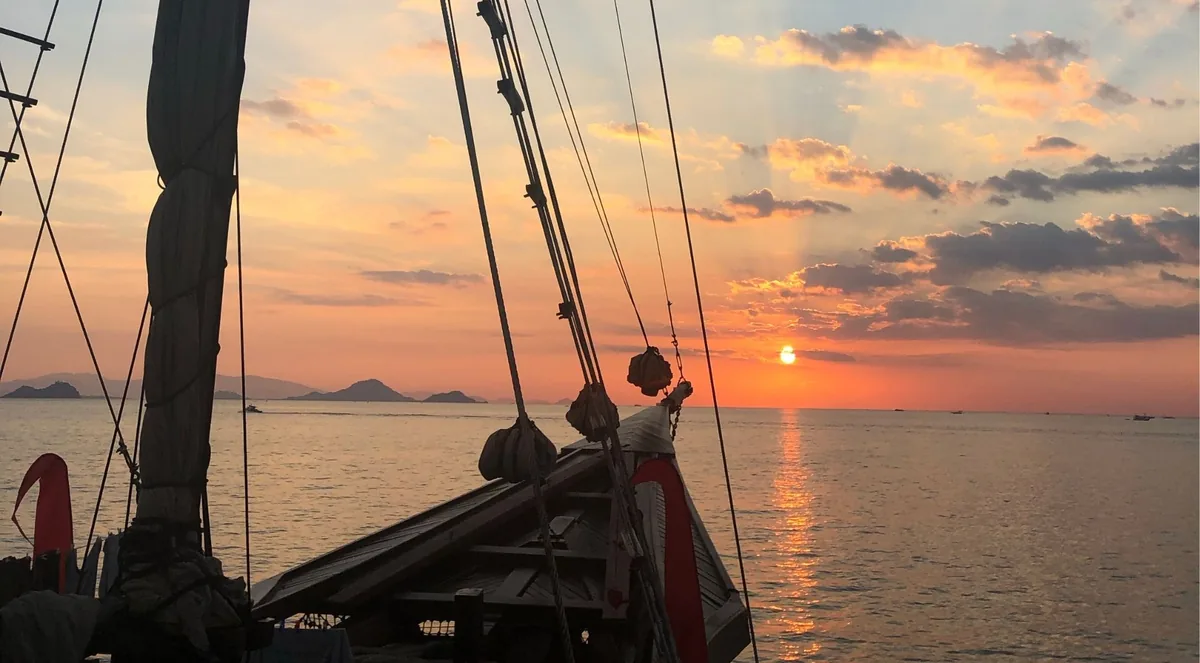 Bow and rigging of a traditional Phinisi liveaboard at sunset near Labuan Bajo